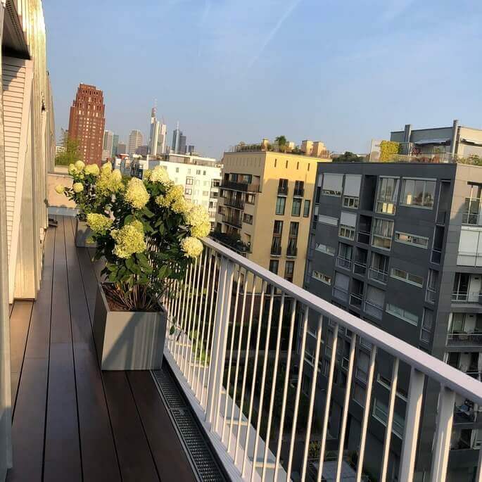 Holzterrasse mit Geländer und Blick über die Dächer von Frankfurt