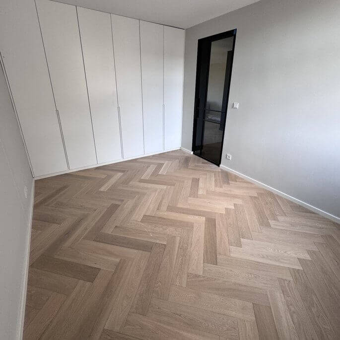 Schlafzimmer mit neu verlegtem Fischgrätparkett in einer Frankfurter Wohnung