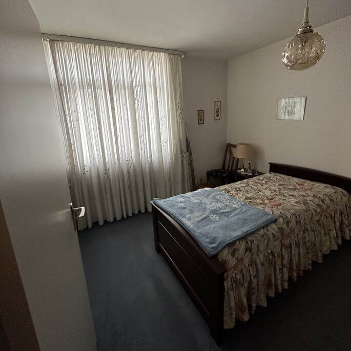 Schlafzimmer mit altem Teppichboden in einer Frankfurter Wohnung vor der Parkettverlegung
