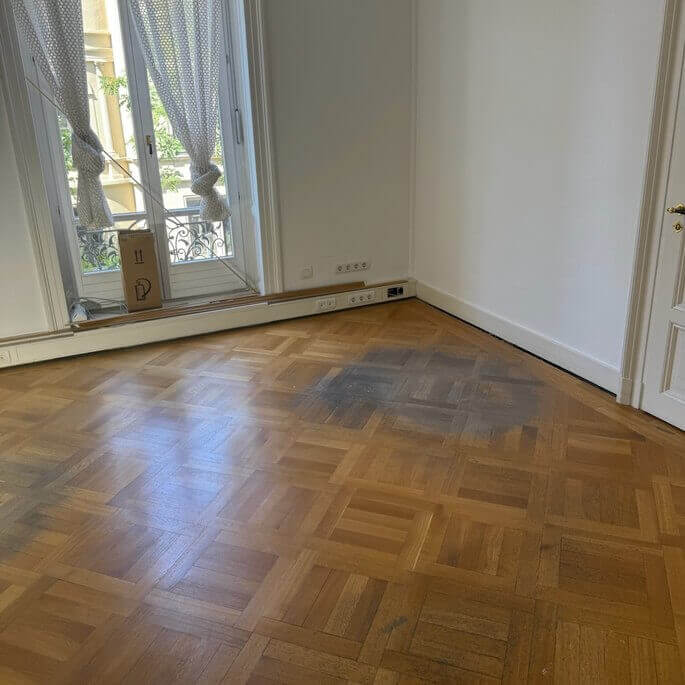 Tafelparkett mit dunklen Flecken in einer Frankfurter Altbauwohnung vor der Aufbereitung