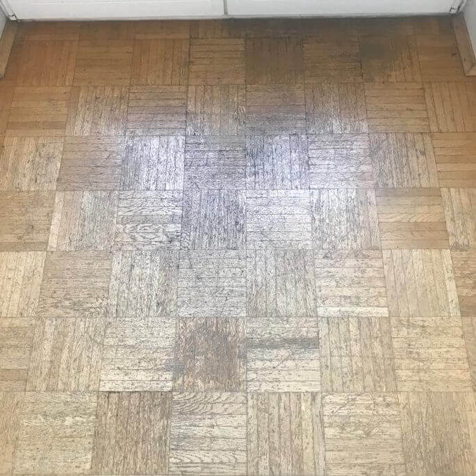 Abgenutztes Tafelparkett in einer Frankfurter Wohnung vor dem Schleifen