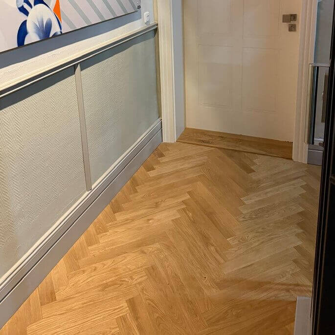 Neu verlegtes Fischgrätparkett im Treppenhaus im Frankfurter Holzhausenviertel