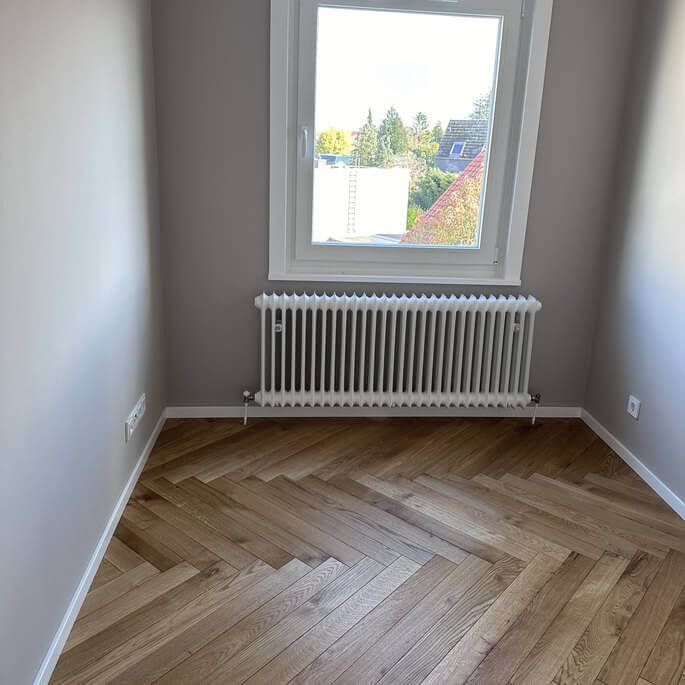 Zimmer mit neu verlegtem Fischgrätparkett aus Eiche in einer Frankfurter Wohnung
