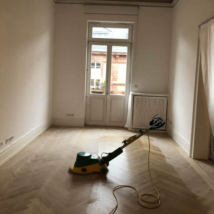 Fischgrätparkett beim Schleifen in einer Altbauwohnung in Frankfurt