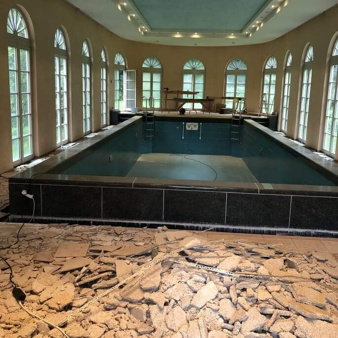 Schwimmhalle mit altem, zerstörtem Bodenbelag vor der Verlegung neuer Holzdielen in Frankfurt