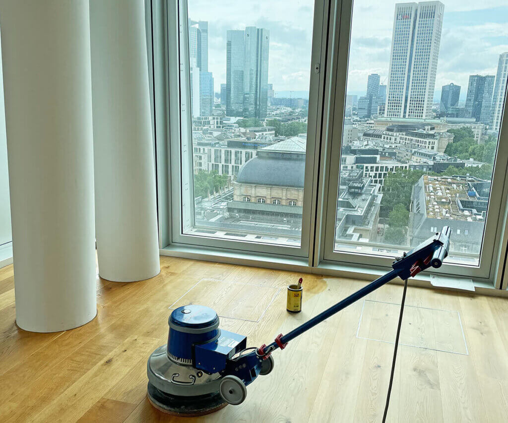 Einscheibenmaschine zum Ölen von Parkett in einer Wohnung mit Blick auf die Frankfurter Skyline